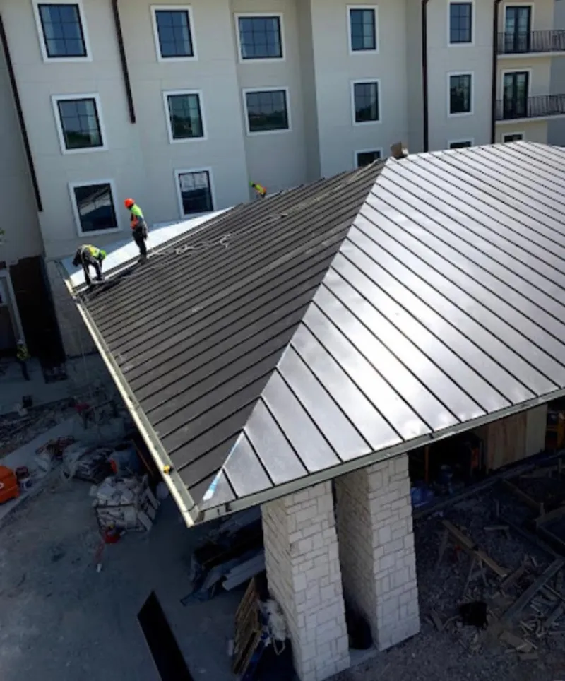 Crew installing standing seam metal roof panels on a commercial project in Paulsboro